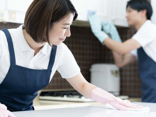 女性が家事代行業務で机を拭いている写真