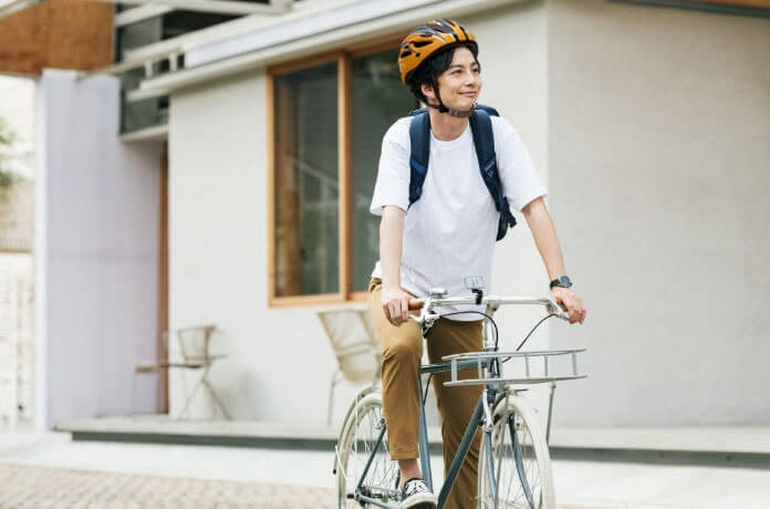 ヘルメットをかぶって自転車で走行中の男性